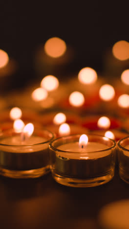 Vertical-Video-Close-Up-Shot-Of-Romantic-Red-And-White-Candles-In-the-Shape-Of-A-Heart-On-Black-Background